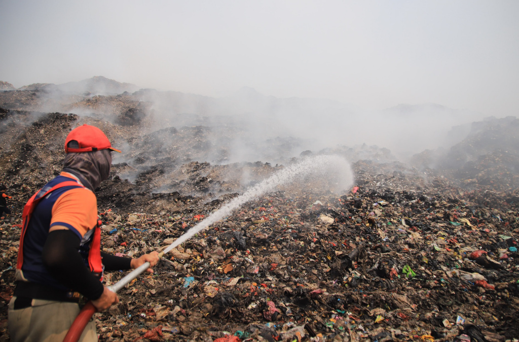 Petugas pemadam kebakaran berusaha memadamkan api di Tempat Pembuangan Akhir (TPA) Jatiwaringin, Kabupaten Tangerang, Banten, Senin (6/7/2026). (Beritanasional.com/Oke Atmaja)