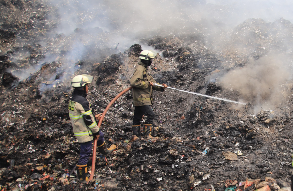 Petugas pemadam kebakaran berusaha memadamkan api di Tempat Pembuangan Akhir (TPA) Jatiwaringin, Kabupaten Tangerang, Banten, Senin (6/7/2026). (Beritanasional.com/Oke Atmaja)
