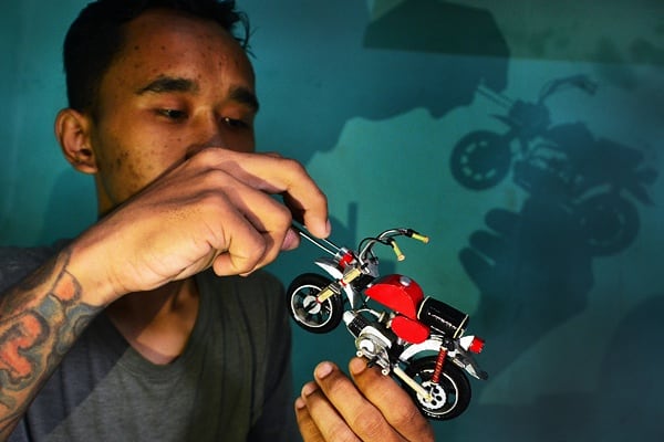 Perajin menyelesaikan pembuatan miniatur motor kastem dari barang bekas. (BeritaNasional/Elvis Sendouw)