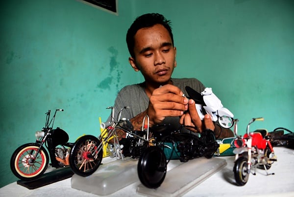 Perajin menyelesaikan pembuatan miniatur motor kastem dari barang bekas. (BeritaNasional/Elvis Sendouw)