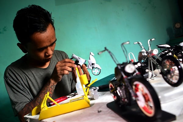 Perajin menyelesaikan pembuatan miniatur motor kastem dari barang bekas. (BeritaNasional/Elvis Sendouw)