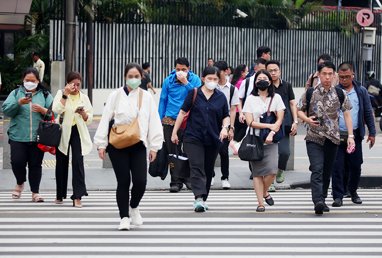 Pekerja berjalan saat jam pulang kerja di kawasan Jenderal Sudirman, Jakarta, Rabu (24/12/2025). (Beritanasional.com/Oke Atmaja)