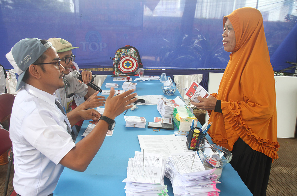 Petugas Kelompok Penyelenggara Pemungutan Suara (KPPS) mengenakan seragam sekolah mengarahkan warga memasukkan surat suara di TPS 05 Petamburan, Tanah Abang, Jakarta, Rabu (27/11/2024).(BeritaNasional.com/Oke Atmaja)