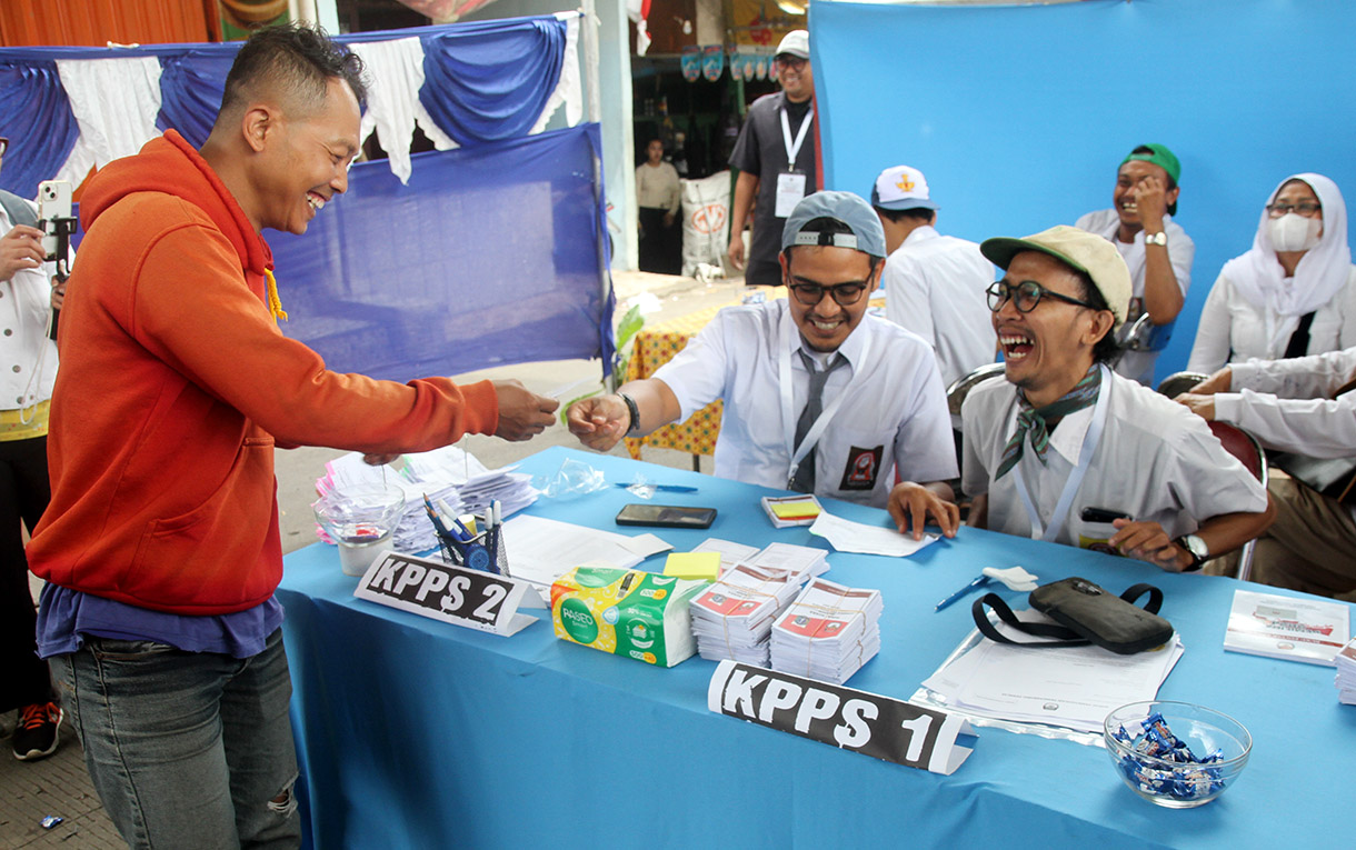 Petugas Kelompok Penyelenggara Pemungutan Suara (KPPS) mengenakan seragam sekolah mengarahkan warga memasukkan surat suara di TPS 05 Petamburan, Tanah Abang, Jakarta, Rabu (27/11/2024).(BeritaNasional.com/Oke Atmaja)