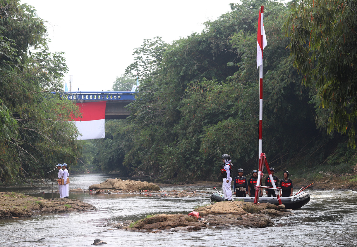 Sejumlah anggota Komunitas Ciliwung mengibarkan bendera Merah Putih saat mengikuti upacara bendera di Sungai Ciliwung, Depok, Jawa Barat, Sabtu, (17/8/2024). (BeritaNasional.com/ Oke Atmaja)