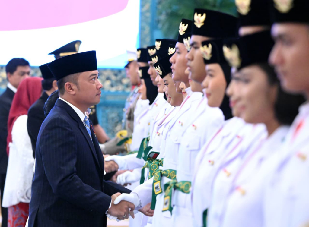 Anggota Paskibraka 2025 asal Papua Barat Ritha Lovely CF Ayomi mencium Bendera Merah-Putih dalam upacara pengukuhan Paskibraka Tingkat Pusat 2025 di Istana Negara, Jakarta, Sabtu (16/8/2025).  (Beritanasional.com/ Biro Pers)