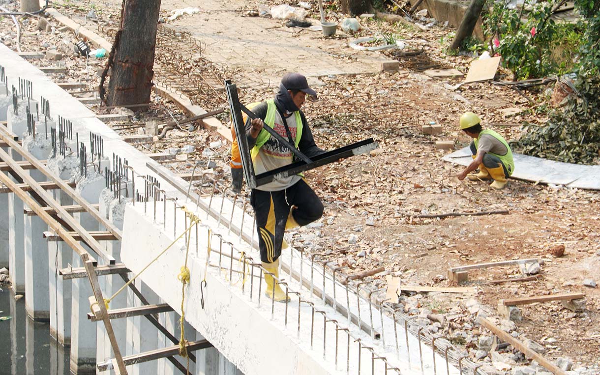 Pekerja menyelesaikan pembangunan turap di Kali Cideng Atas, Jalan HR Rasuna Said, Jakarta, Sabtu (13/6/2026).(Beritanasional.com/Oke Atmaja)