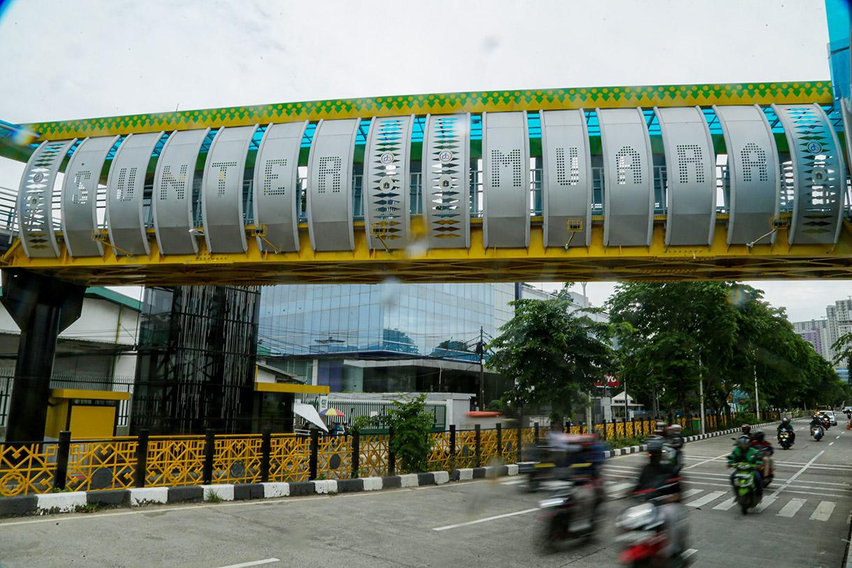 Warga berjalan di jembatan penyeberangan orang (JPO) Sunter Muara, Jakarta, Kamis (19/12/2024).(BeritaNasional.com/Oke Atmaja)