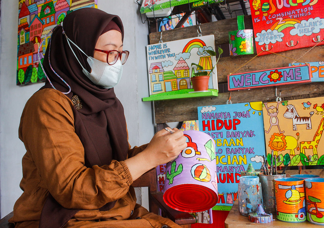 Lani Cahyaningsari melukis kaleng bekas, Depok, Jawa Barat, Minggu (7/7/2024). (BeritaNasional.com/Oke Atmaja)