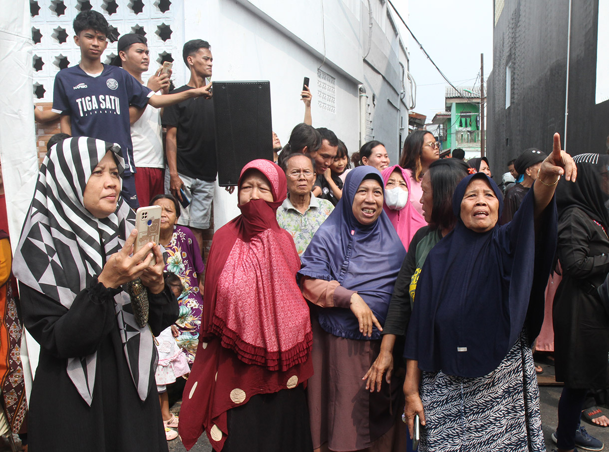 Sejumlah warga menyaksikan upacara pelepasan jenazah Wapres ke-9 Hamzah Haz di Jalan Tegalan, Matraman, Jakarta, Rabu (24/7/2024).  (BeritaNasional.com/Oke Atmaja)