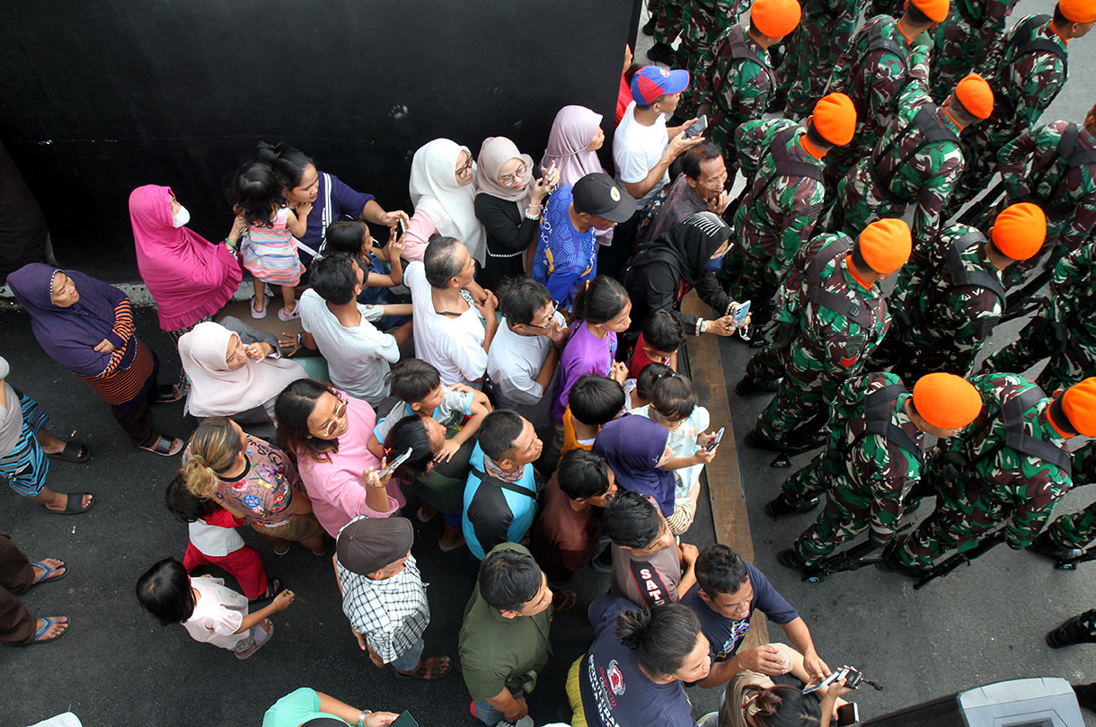 Sejumlah warga menyaksikan upacara pelepasan jenazah Wapres ke-9 Hamzah Haz di Jalan Tegalan, Matraman, Jakarta, Rabu (24/7/2024).  (BeritaNasional.com/Oke Atmaja)