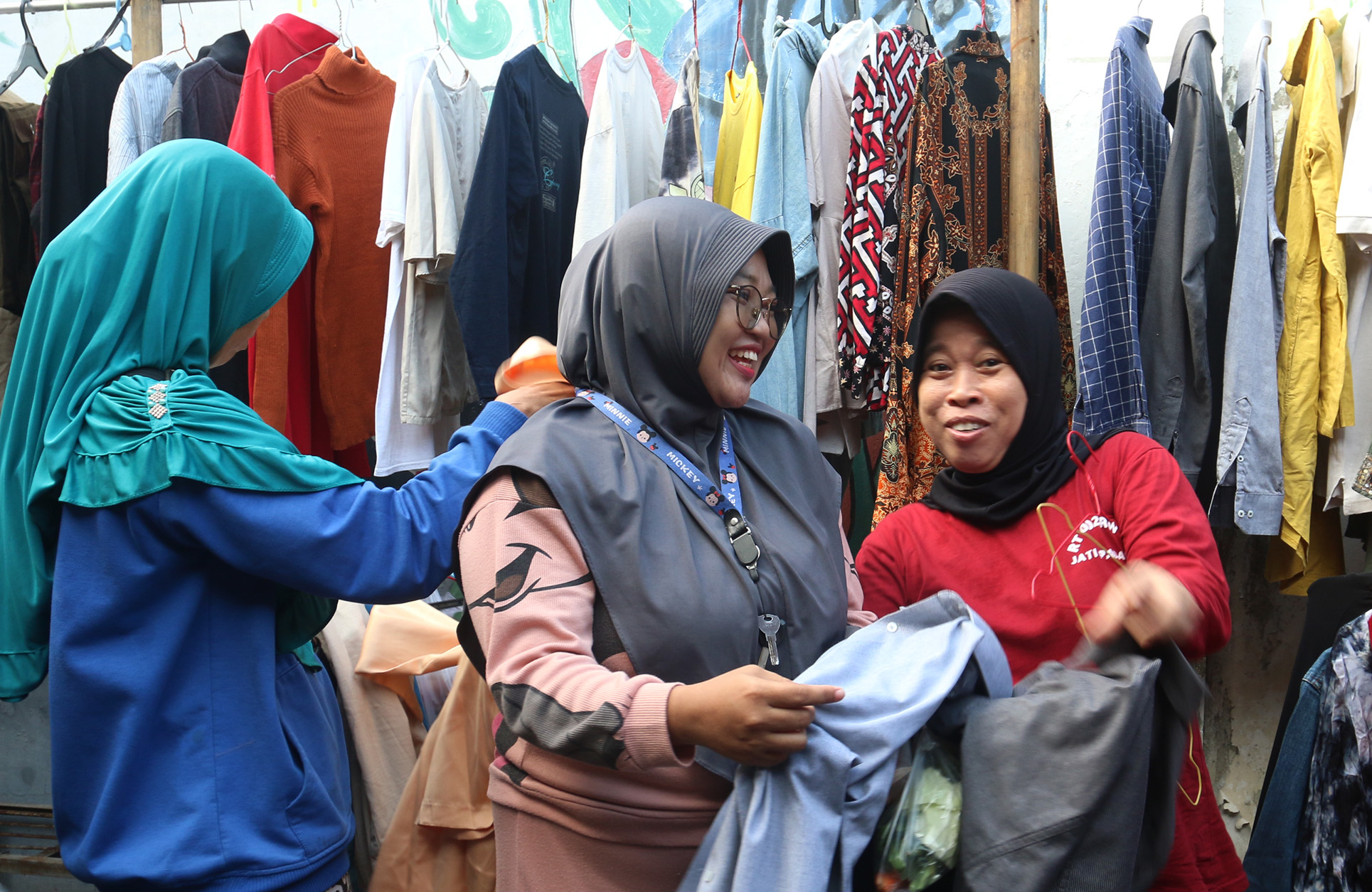 Warga memilih sayur dan pakaian bekas saat bazzar sayuran, bahan makanan dan pakaian layak pakai gratis di Jalan Jati Padang VI, Pasar Minggu, Jakarta, Jumat (29/03/2024).(Indonesiaglobe/Oke Atmaja)