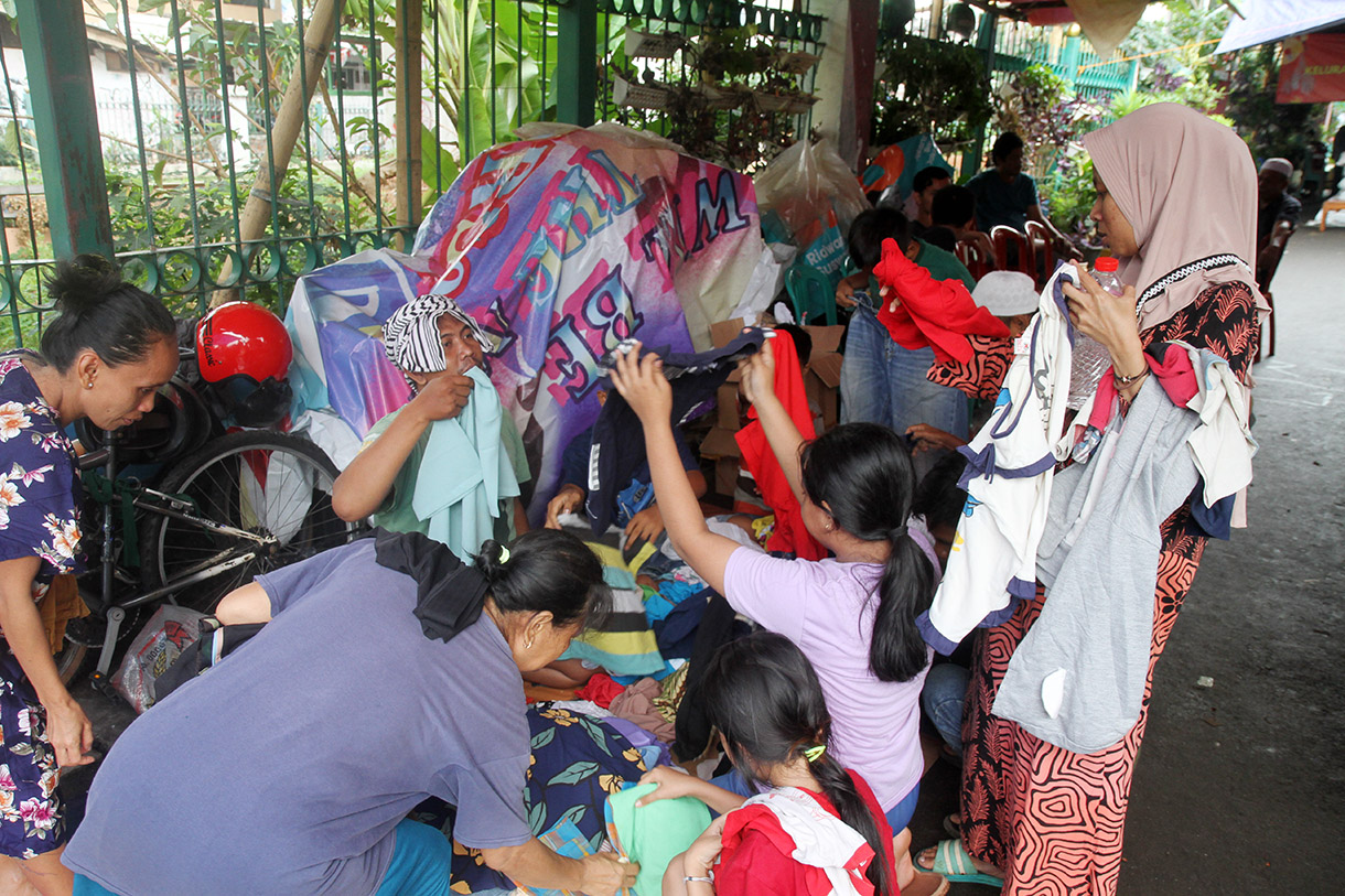 Warga terdampak kebakaran Menteng memilah sumbangan baju layak pakai di posko pengungsian Menteng, Jakarta, sabtu (21/12/2024). (BeritaNasional.com/Oke Atmaja)