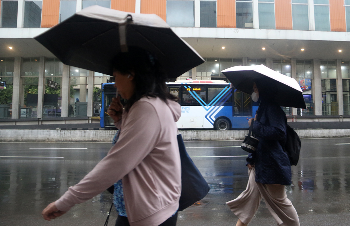 Pekerja melintas di jalan MH. Thamrin,Jakarta, Senin (12/1/2025). (Beritanasional.com/Oke Atmaja)
