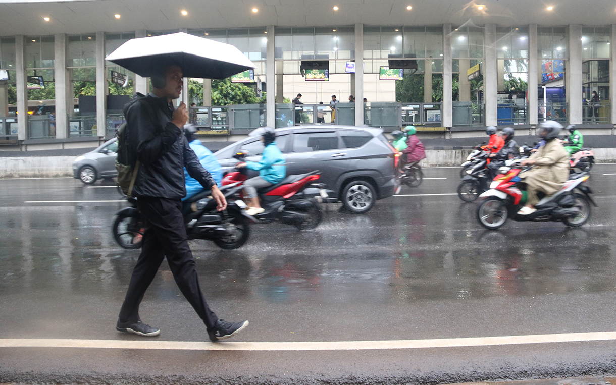 Pekerja melintas di jalan MH. Thamrin,Jakarta, Senin (12/1/2025). (Beritanasional.com/Oke Atmaja)