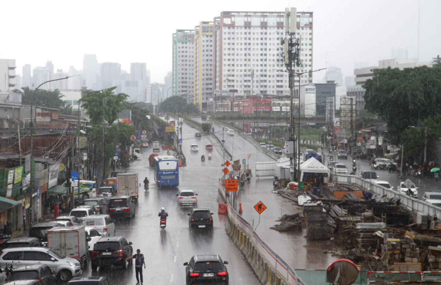 Warga melintas saat hujan mengguyur di Kawasan Jalan Pramuka Jakarta Kamis (27/6/2024).(Beritanasional.Com/Oke Atmaja)