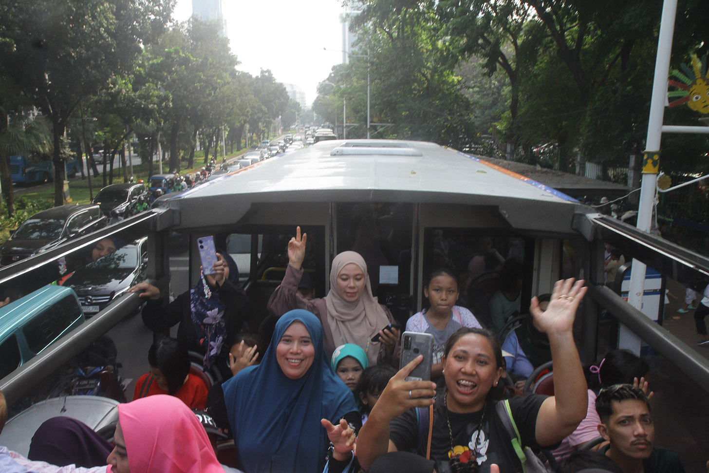 Sejumlah penumpang menaiki bus tingkat pariwisata gratis di kawasan Monas, Jakarta,minggu (7/7/2024).(BeritaNasional.com/Oke Atmaja)