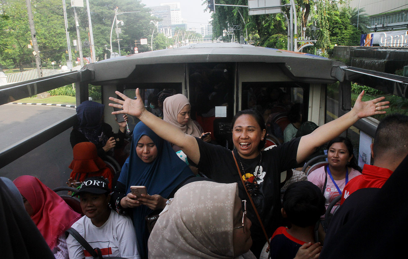 Sejumlah penumpang menaiki bus tingkat pariwisata gratis di kawasan Monas, Jakarta,minggu (7/7/2024).(BeritaNasional.com/Oke Atmaja)