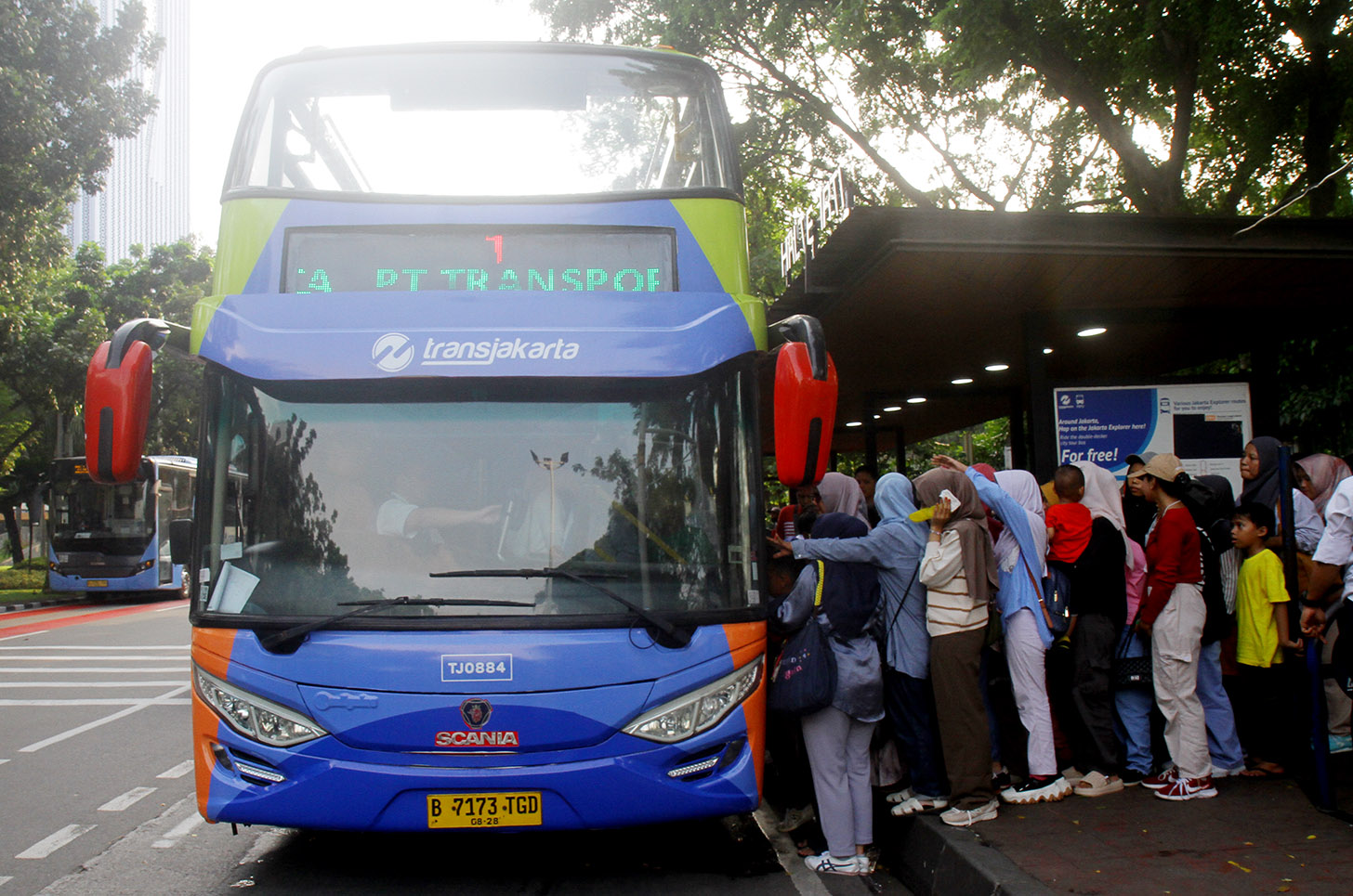 Sejumlah penumpang menaiki bus tingkat pariwisata gratis di kawasan Monas, Jakarta,minggu (7/7/2024).(BeritaNasional.com/Oke Atmaja)