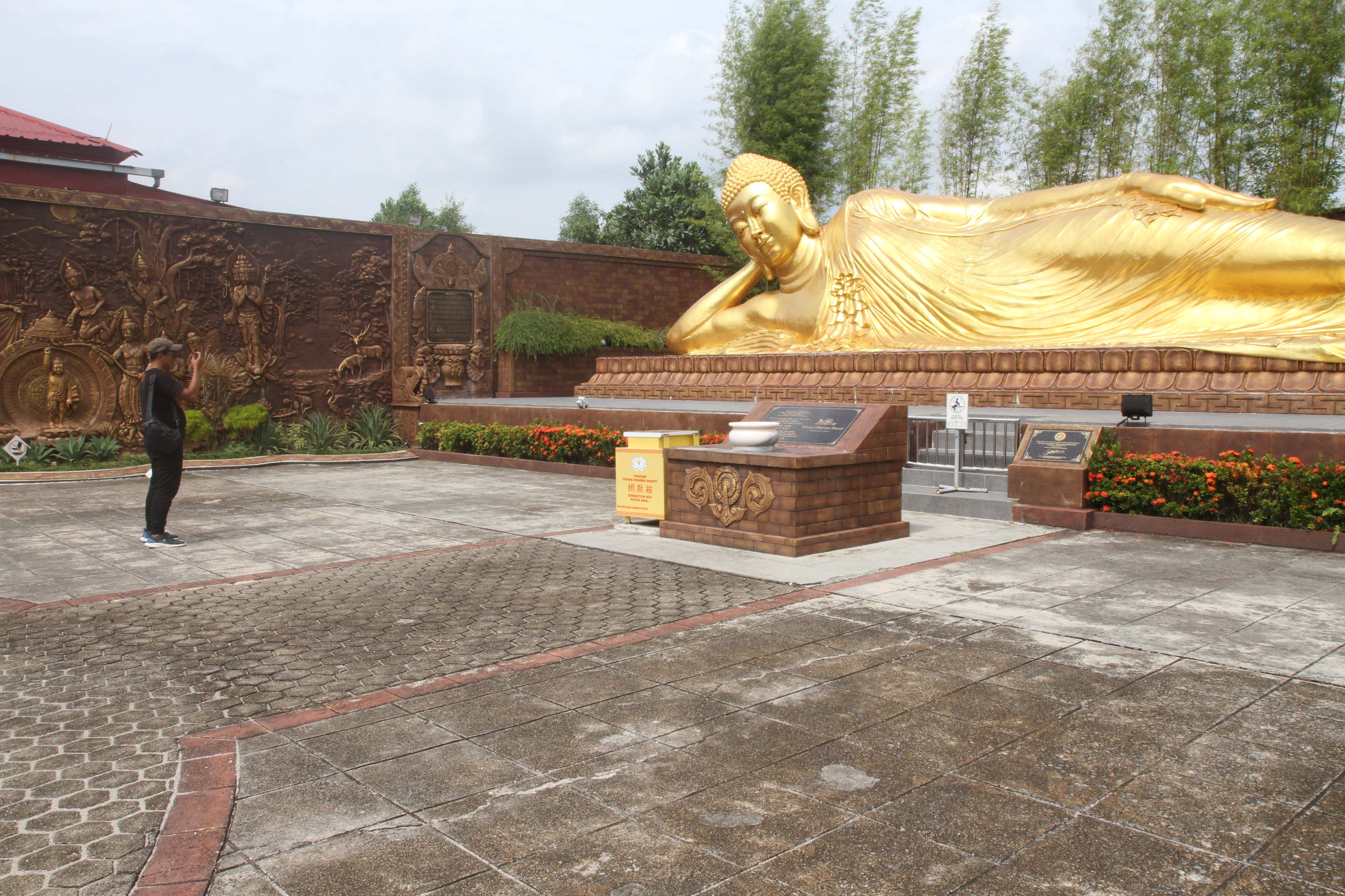 Warga memotret Patung Buddha Tidur di Vihara Dharma Shanti, Tanjung Uban, Bintan, Kepulauan Riau, Kamis (05/12/2024).(BeritaNasional.com/Oke Atmaja)