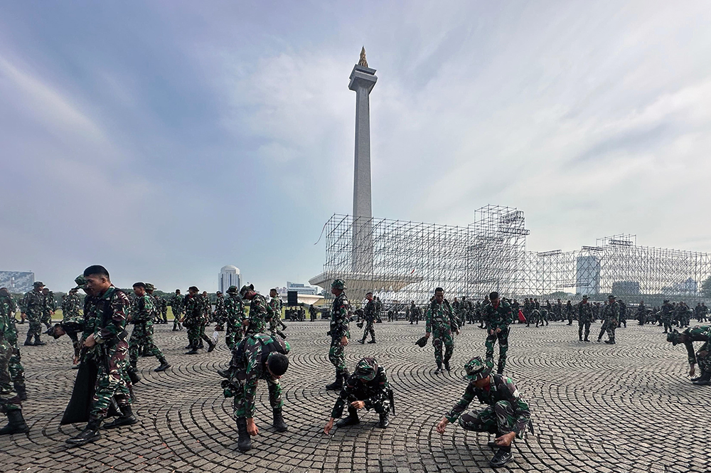 Prajurit Yonif 330 Tri Dharma membersihkan sampah di kawasan lingkungan lapangan silang Monas. (BeritaNasional/HO TNI/Elvis Sendouw)