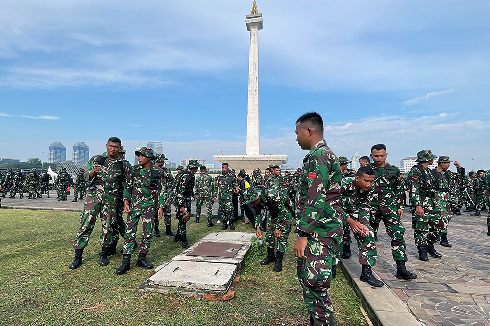 Prajurit Yonif 330 Tri Dharma membersihkan sampah di kawasan lingkungan lapangan silang Monas. (BeritaNasional/HO TNI/Elvis Sendouw)