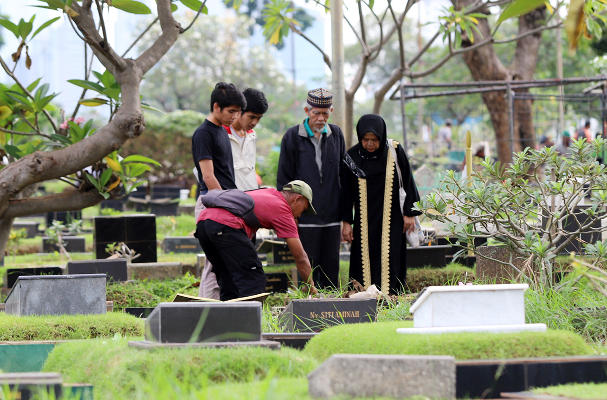 Sejumlah warga berdoa menaburkan bunga di makam keluarganya di tempat pemakaman umum Karet Bivak,Jakarta, Jumat(28/2/2025). (Beritanasional.com/Oke Atmaja)