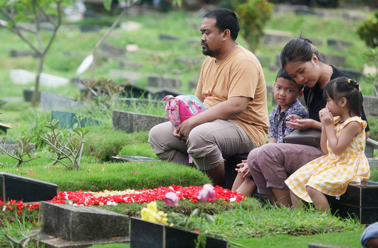 Sejumlah warga berdoa menaburkan bunga di makam keluarganya di tempat pemakaman umum Karet Bivak,Jakarta, Jumat(28/2/2025). (Beritanasional.com/Oke Atmaja)