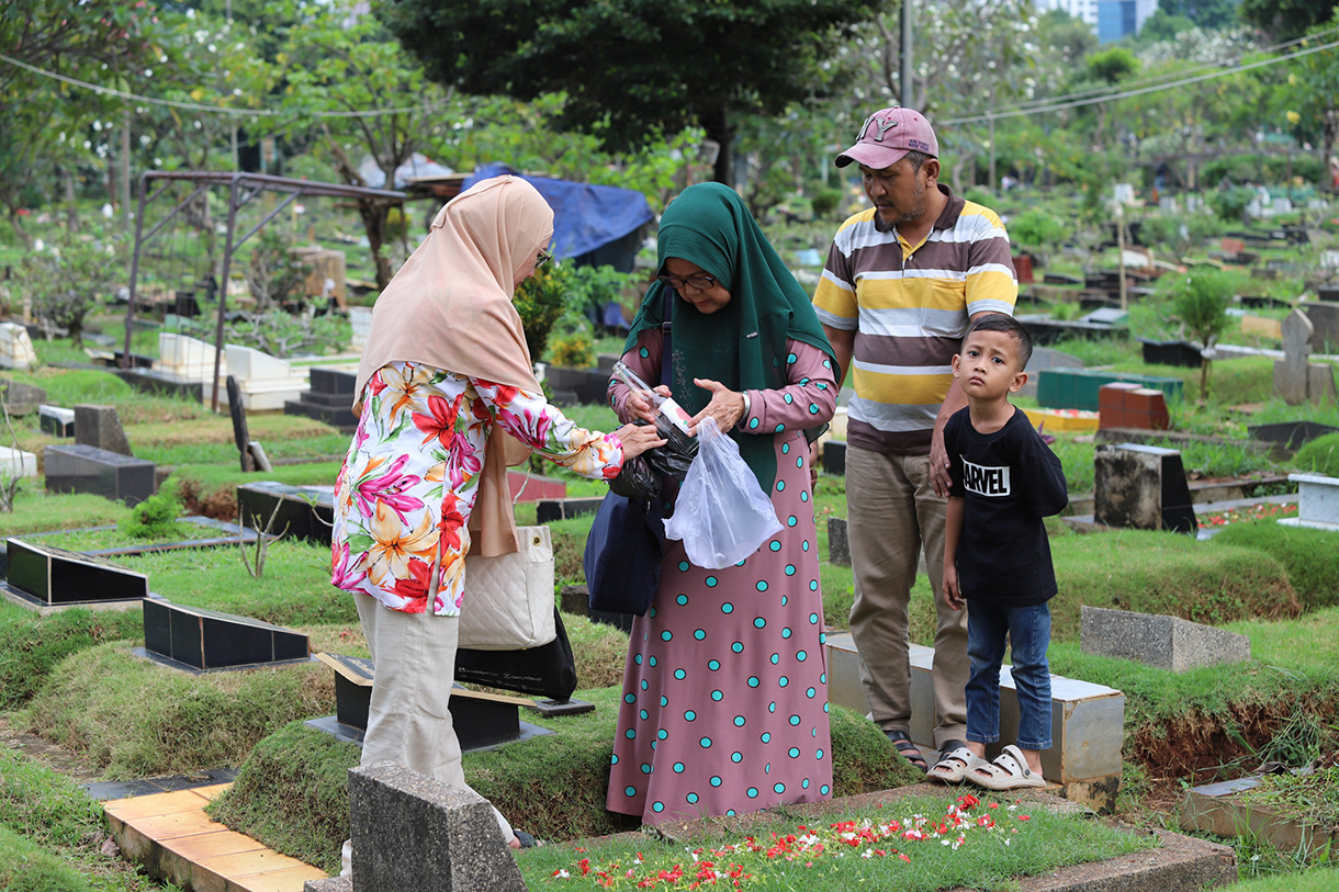 Sejumlah warga berdoa menaburkan bunga di makam keluarganya di tempat pemakaman umum Karet Bivak,Jakarta, Jumat(28/2/2025). (Beritanasional.com/Oke Atmaja)