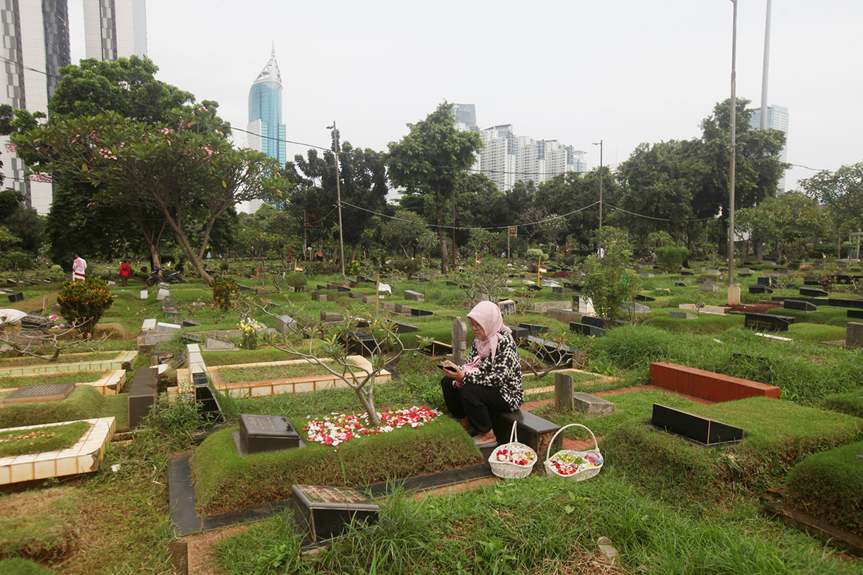 Sejumlah warga berdoa menaburkan bunga di makam keluarganya di tempat pemakaman umum Karet Bivak,Jakarta, Jumat(28/2/2025). (Beritanasional.com/Oke Atmaja)